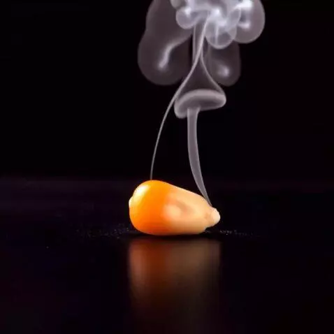 AI Video from prompt: A close-up shot of a single popcorn kernel heati