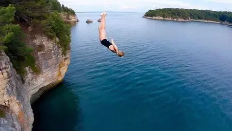 AI Video from prompt: girl diving elegant from clif