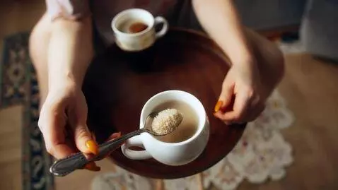 AI Video from prompt: A Russian woman puts a spoonful of sugar into a 