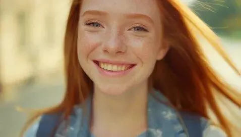 AI Video from prompt: A beautiful red-haired girl smiles flirtatiously