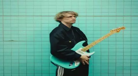 AI Video from prompt: Мужчина берёт гитару которая висит у него сперед