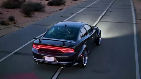 AI Video from prompt: Low drone skims above the Charger's rakish roofl