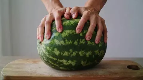 AI Video from prompt: A whole watermelon is lying on a wooden cutting 
