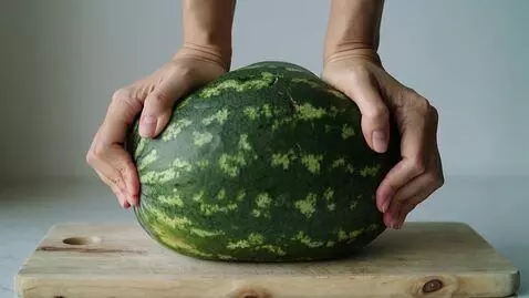 AI Video from prompt: A whole watermelon is lying on a wooden cutting 