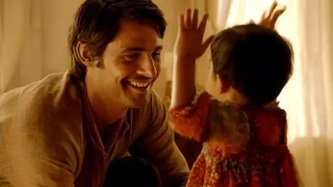 AI Video from prompt: Un homme qui s'accroupit en souriant parlant à l