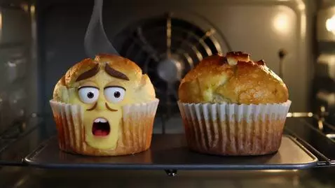 AI Video from prompt: Inside a warm, glowing oven, two golden-brown mu