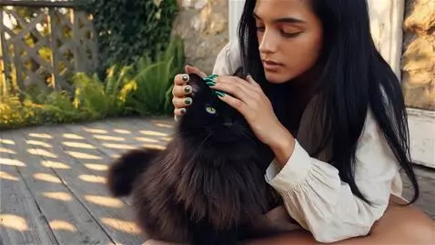 AI Video from prompt: A young brunette woman with long black hair sits