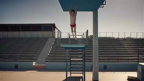 AI Video from prompt: Мальчик прыгает с высокой вышки в бассейн