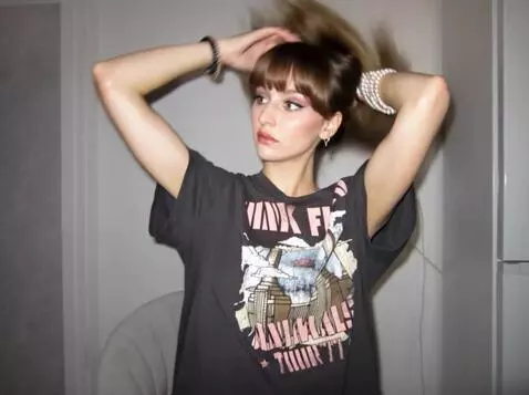 AI Video from prompt: girl touches her hair.  The camera seems to be s