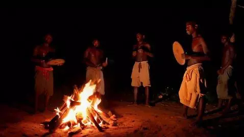 AI Video from prompt: African men dancing around a fire and hitting th