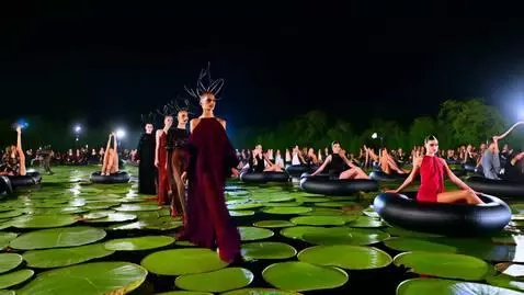 AI Video from prompt: A couture fashion show on a dark lake, they are 