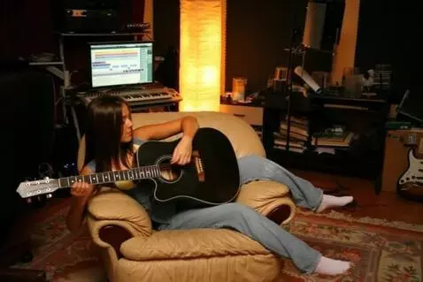 AI Video from prompt: девушка играет на гитаре, а из струн вылетают ис