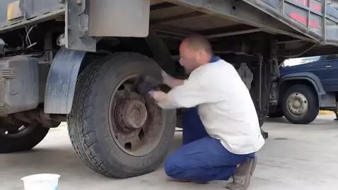 AI Video from prompt: A car technician replacing a sparepart on the tr