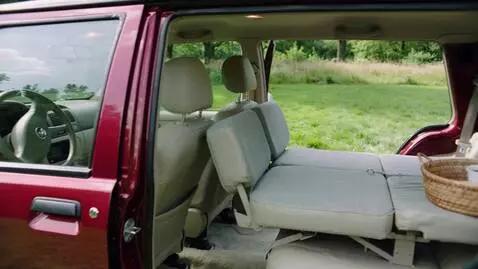 AI Video from prompt: The camera starts by filming a red hatchback fro