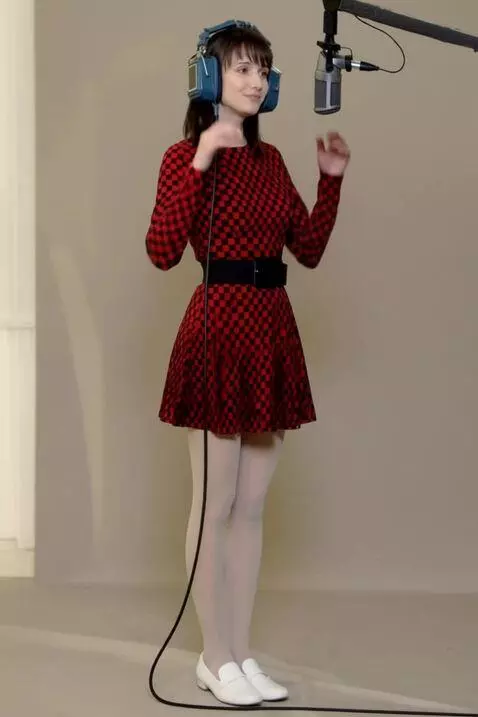 AI Video from prompt: A woman sings, holding headphones to her head. T