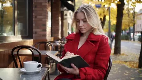 AI Video from prompt: девушка, блондинка сидит за столиком на улице ую