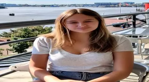 AI Video from prompt: Standing up, her clothes turn into sheer v-neck 