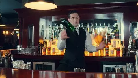 AI Video from prompt: A bartender is juggling three bottles. One slips