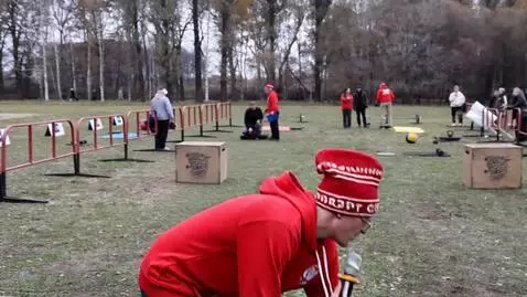 AI Video from prompt: a man in red picks up a weight that is lying in 