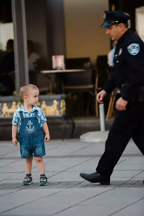 AI Video from prompt: "A kind police officer kneeling down to talk to 