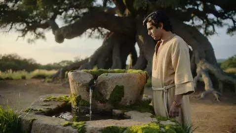 AI Video from prompt: Emir is standing by an ancient, dry stone well o