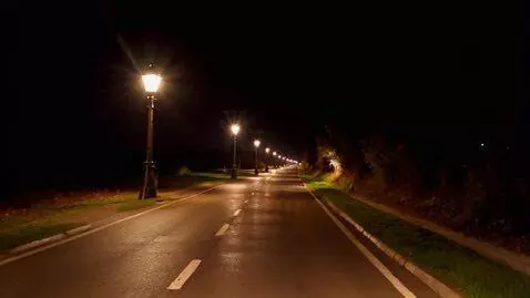 AI Video from prompt: The paved road glistens in the dim light of the 