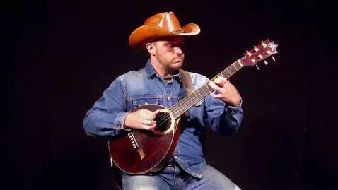 AI Video from prompt: Музыкант в ковбойском костюме играет на банджо