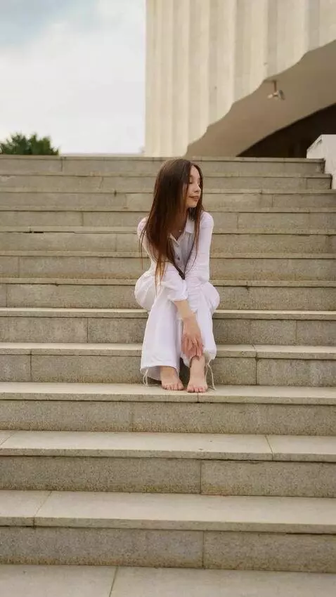 AI Video from prompt: A barefoot girl clad in loose, flowing white gar