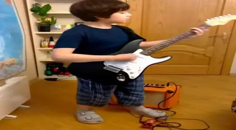 AI Video from prompt: Put this guy with a guitar on a rock stage. He p