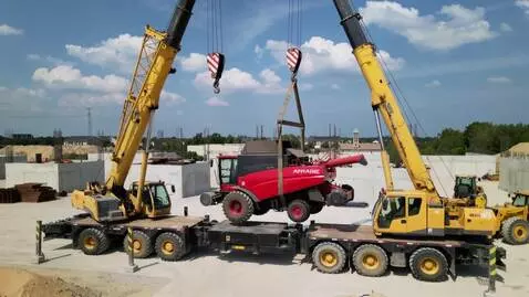 AI Video from prompt: 2 автокрана поднимают комбайн