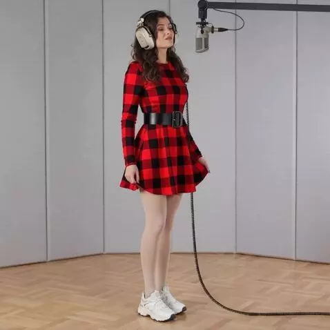 AI Video from prompt: A woman with headphones is singing. She holds on