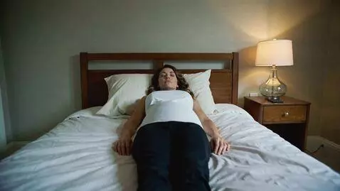 AI Video from prompt: a woman fall asleep then her belly inflation and