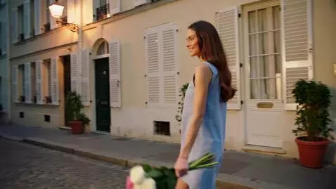 AI Video from prompt: A beautiful young woman walking down a charming 