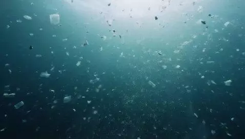 AI Video from prompt: Dark, slow-motion footage of microplastics / tex
