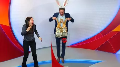 AI Video from prompt: a man in a blue suit grows rabbit ears and jumps