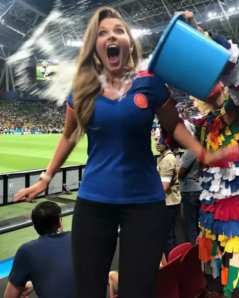 AI Video from prompt: Болельщица выливает ведро воды на зрителя сзади 