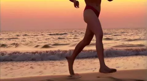 AI Video from prompt: a red-haired woman runs along the beach in a spo