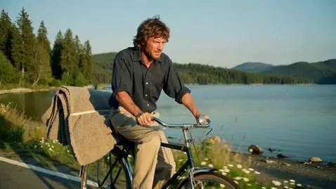 AI Video from prompt: A drunk man is riding a bicycle near the lake to