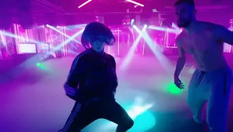 AI Video from prompt: In a neon-lit nightclub, the Harlequin dancer wi