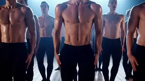 AI Video from prompt: A formation of shirtless male dancers stands in 