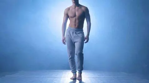 AI Video from prompt: A single shirtless male dancer stands center sta