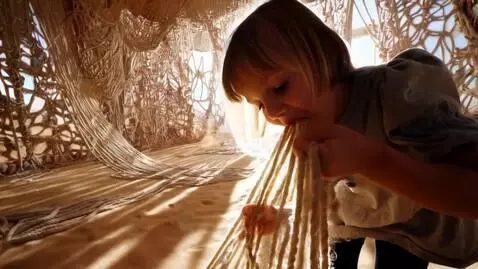 AI Video from prompt: A child in a desert of ropes (a spiderweb room) 