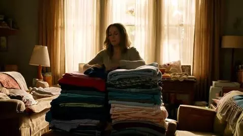 AI Video from prompt: A tired mom finally gets done folding a whole pi