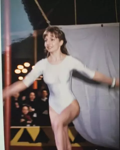 AI Video from prompt: Цирковая артистка на арене цирка плавно делает п