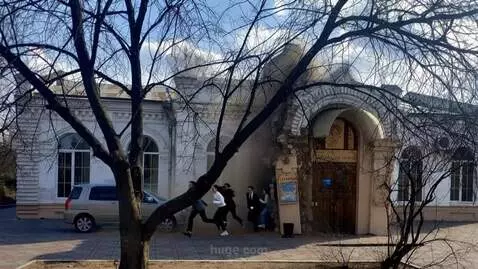 AI Video from prompt: A man in a gray suit runs out of a hole in the w