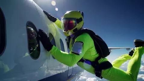 AI Video from prompt: A skydiver in a bright neon jumpsuit and helmet 