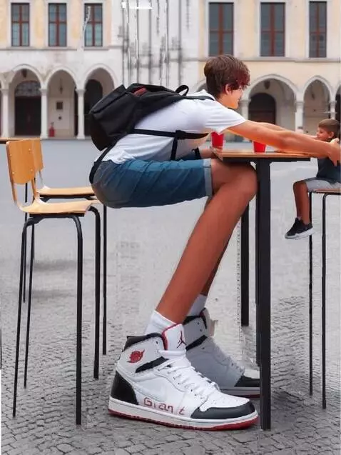 AI Video from prompt: A tall boy takes a small boy sitting across from