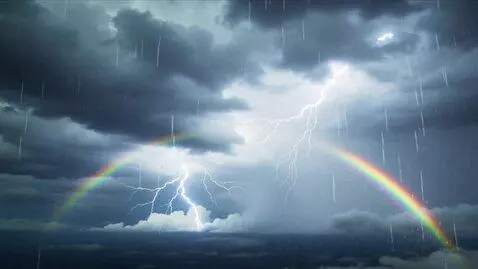 AI Video from prompt: A bright beautiful rainbow beams through dark th