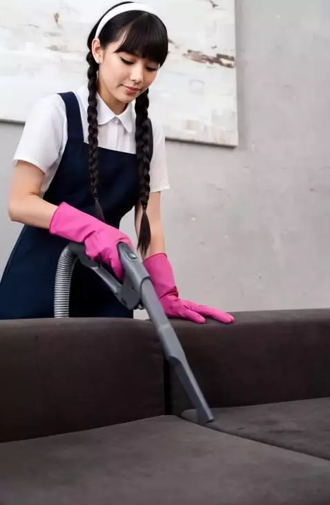 AI Video from prompt: Она пылесосит весь диван. Держит пылесос обеими 