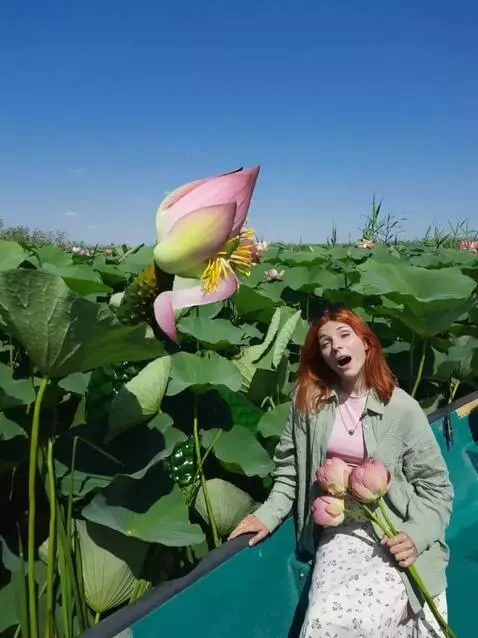 AI Video from prompt: Женщина в лодке держит цветы лотоса среди густог